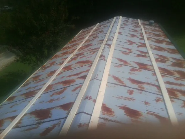Rusted metal roof panels with new wood purlins before replacement — Storm Damage Roof Repair in Delaplane by Roofing Brothers