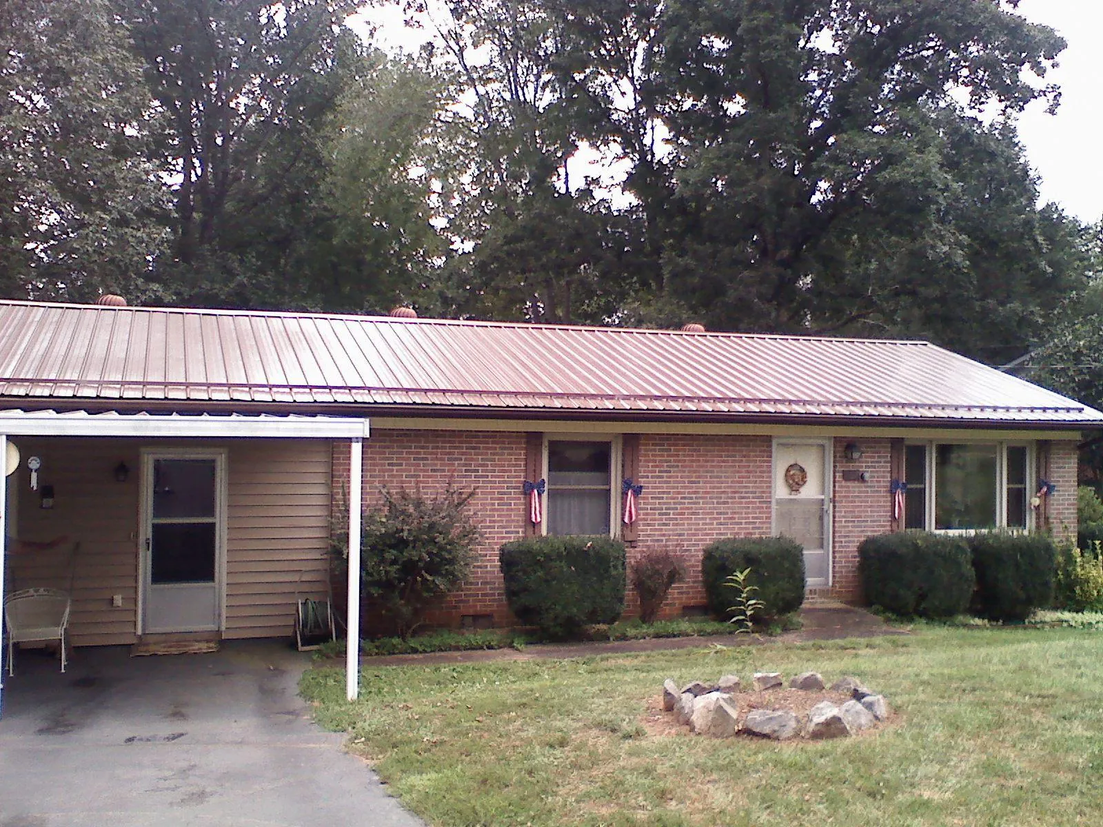 Bronze metal roof and carport on a brick ranch home — Roof Repair work by our crew in Delaplane